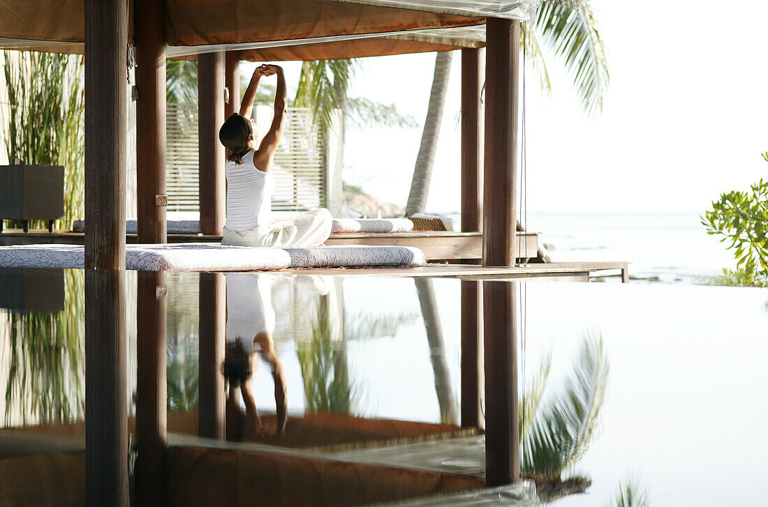 Frau beim Dehnen, Spiegelung im Wasser, Sommer, Urlaub, Wellness