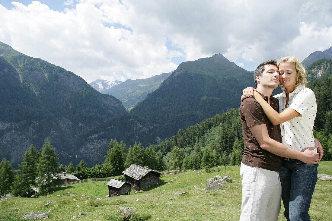Junges Paar umarmt sich auf einer Alm, Heiligenblut, Nationalpark Hohe Tauern, Kärnten, Österreich