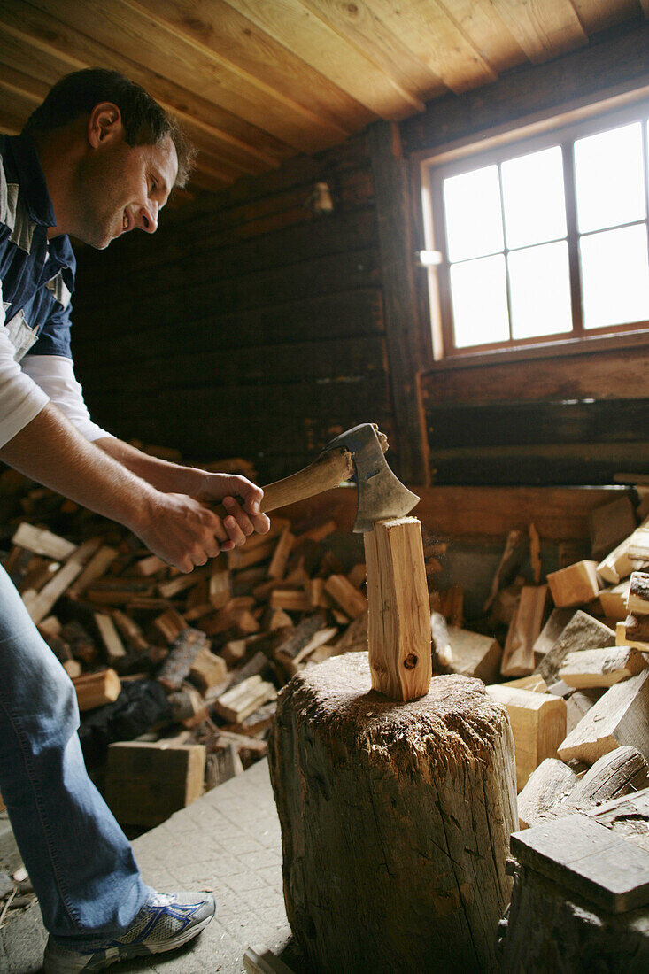 Man chopping wood on alp, Heiligenblut, Hohe Tauern National Park, Carinthia, Austria