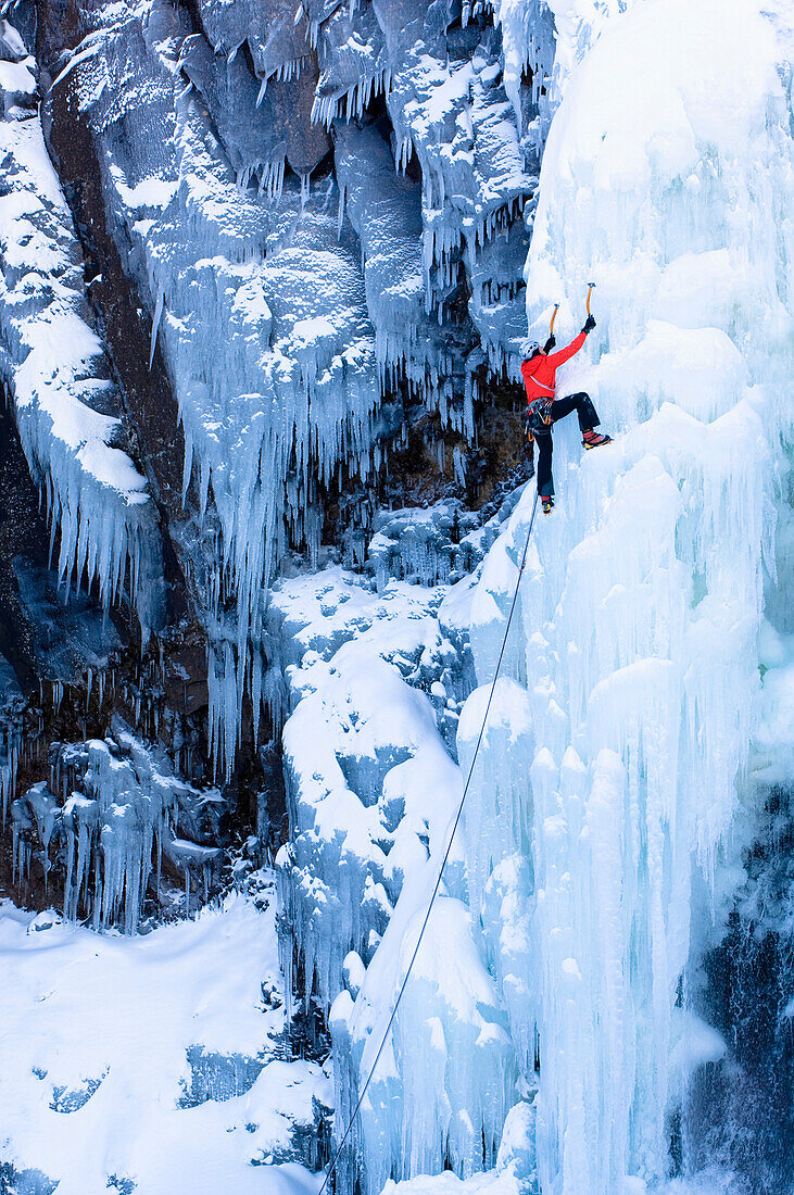Ice climber on frozen waterfall, Seydisfjördur, Austurland, Iceland