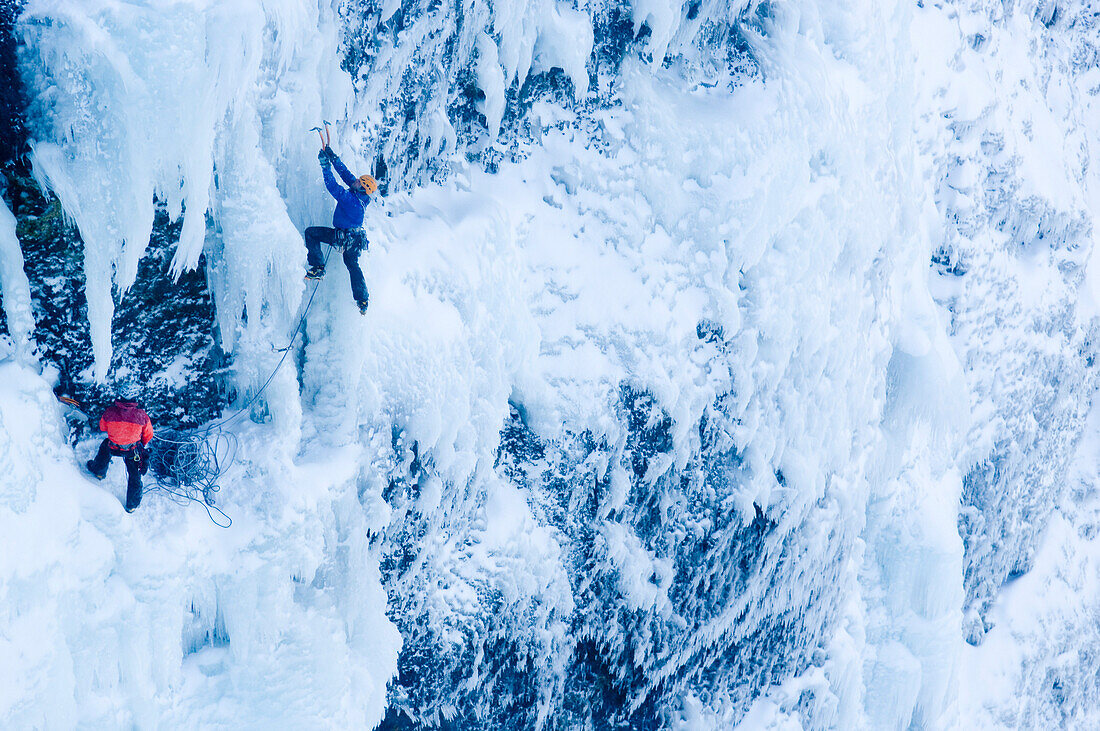 Eiskletterer an gefrorenem Wasserfall, Island