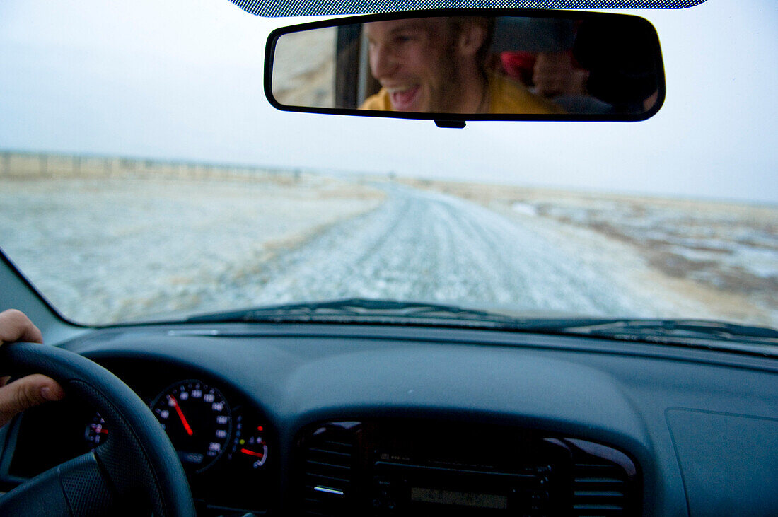Auto-Cockpit mit Fahrer im Rückspiegel, Island