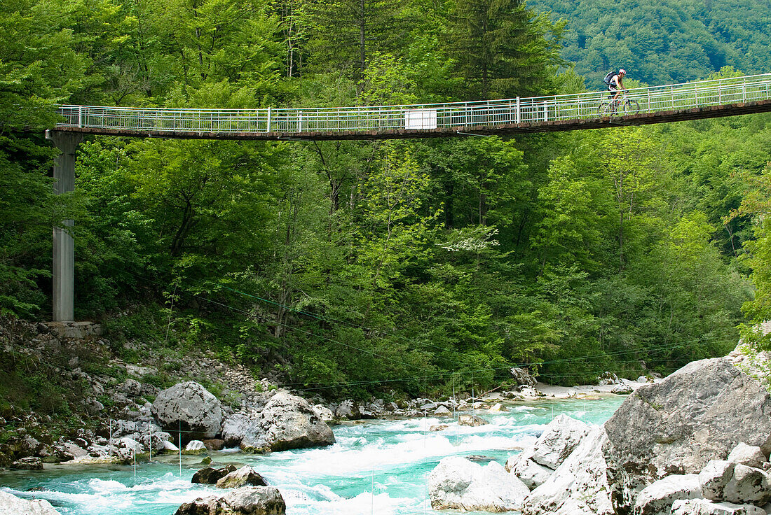 Mountainbiker auf einer Hängebrücke über Soca, Nationalpark Triglav, Slowenien