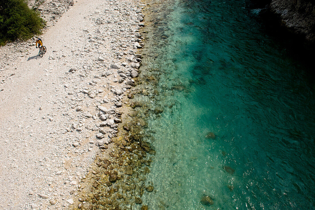 Mountainbiker moving along river, Slovenia