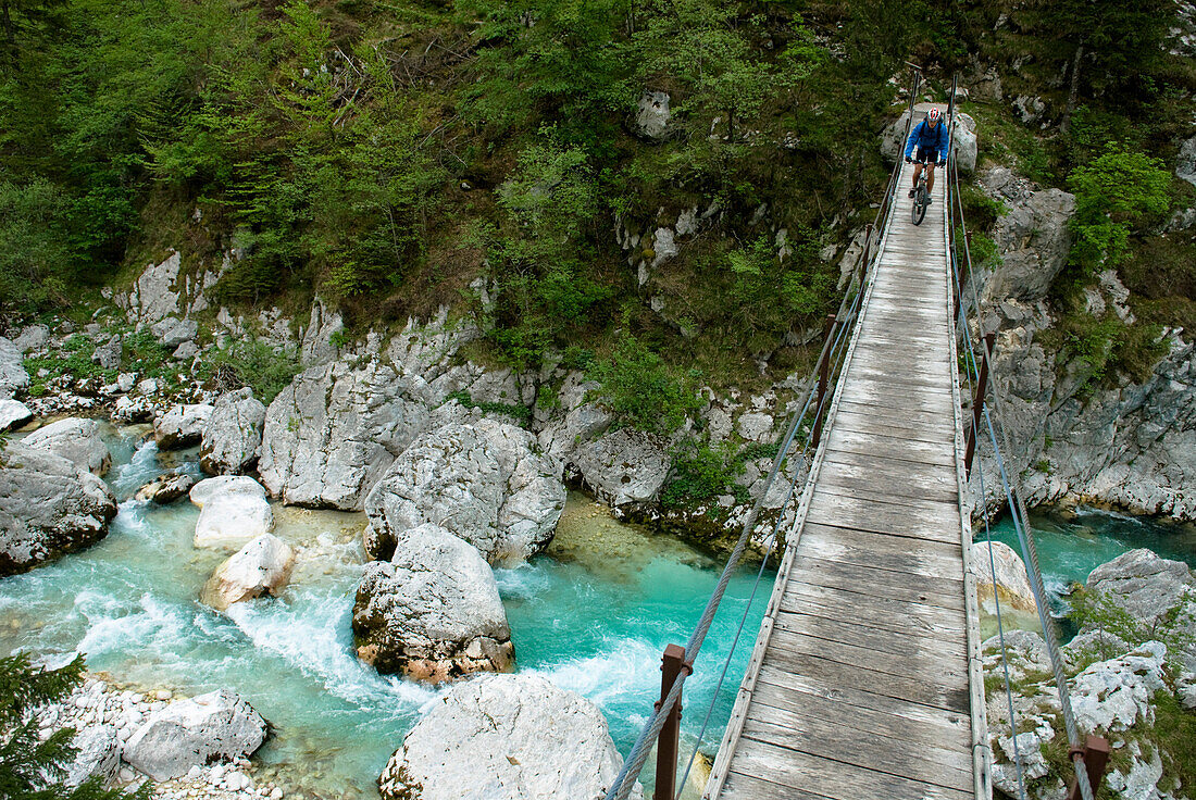Mountainbiker auf einer Hängebrücke über Soca, Nationalpark Triglav, Slowenien