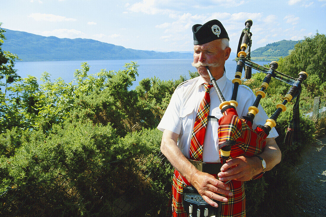 Pipe musician at Loch Ness. Highlands. Scotland