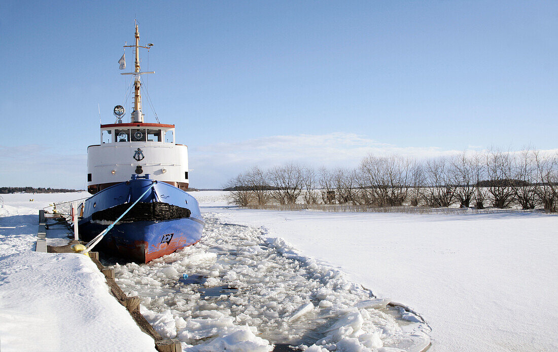 A tug boat at wintertime in the harbour in Västerås, Sweden