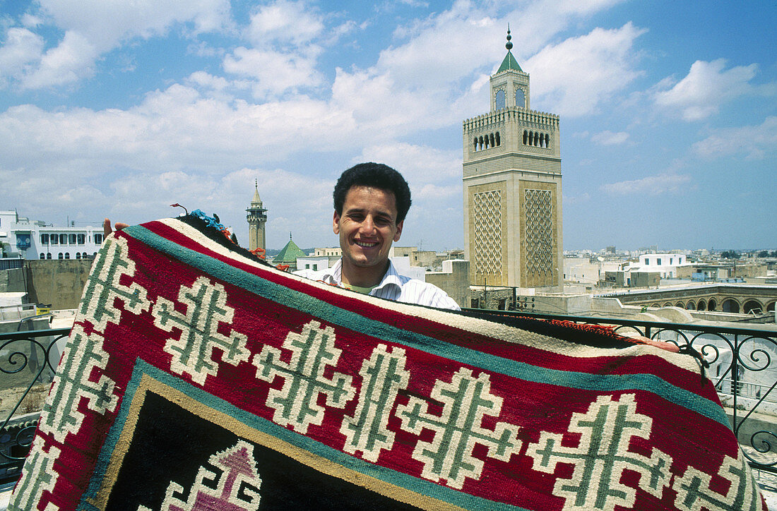 Carpet seller. Souq. Zitouna mosque at the back (XVIIth century). Tunis. Tunisia.