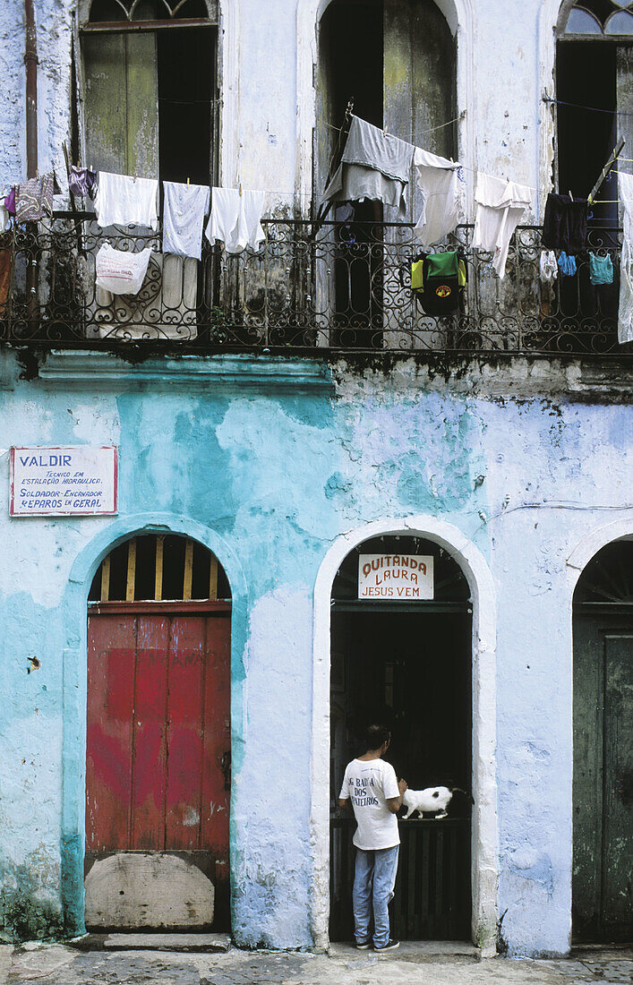 Man and cat at an old housing entrance. Pelourinho (old city) neighborhood. Salvador da Bahia. Brazil
