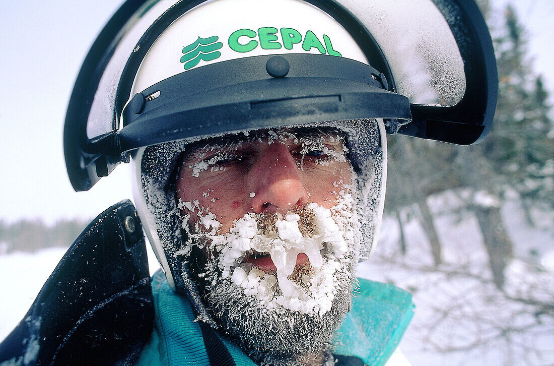 Man with ice covered face after a snowmobile race in winter. Quebec. Canada