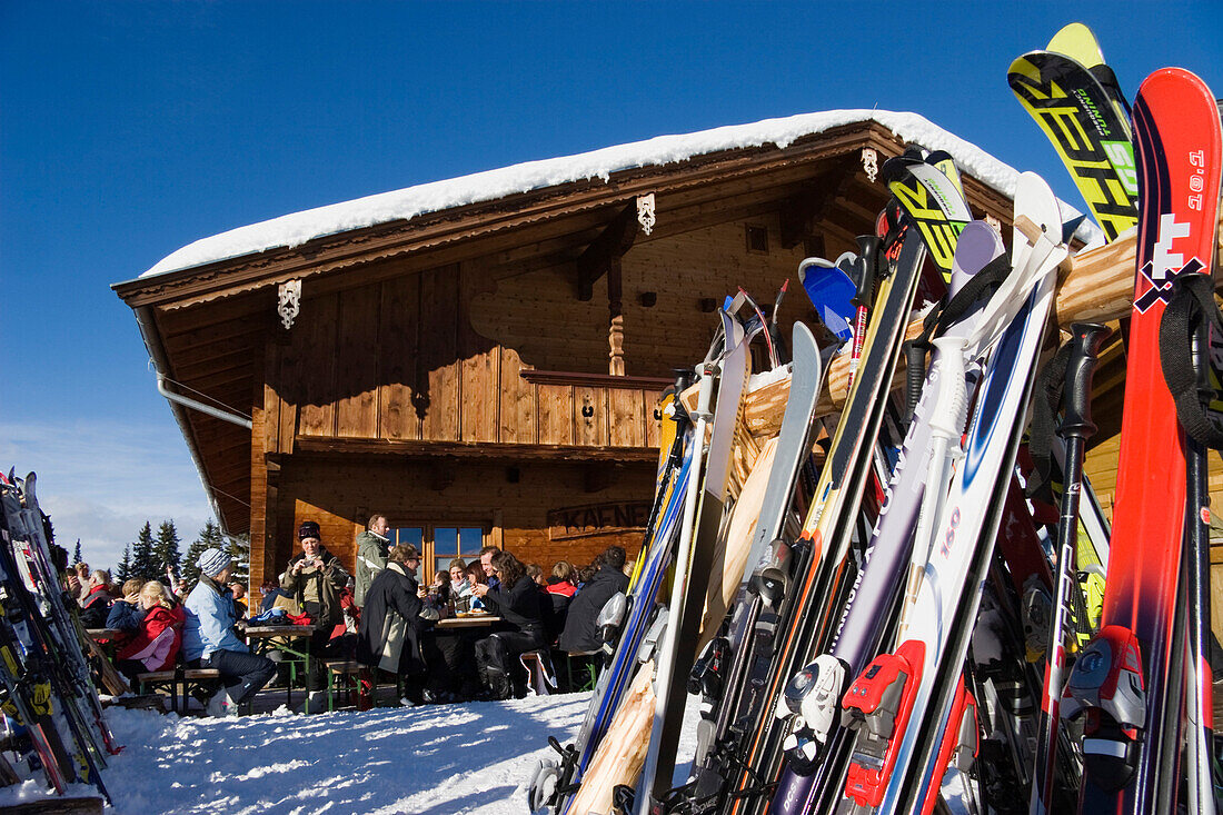 Skifahrer sitzen vor einer Skihütte, Bayerische Alpen, Deutschland