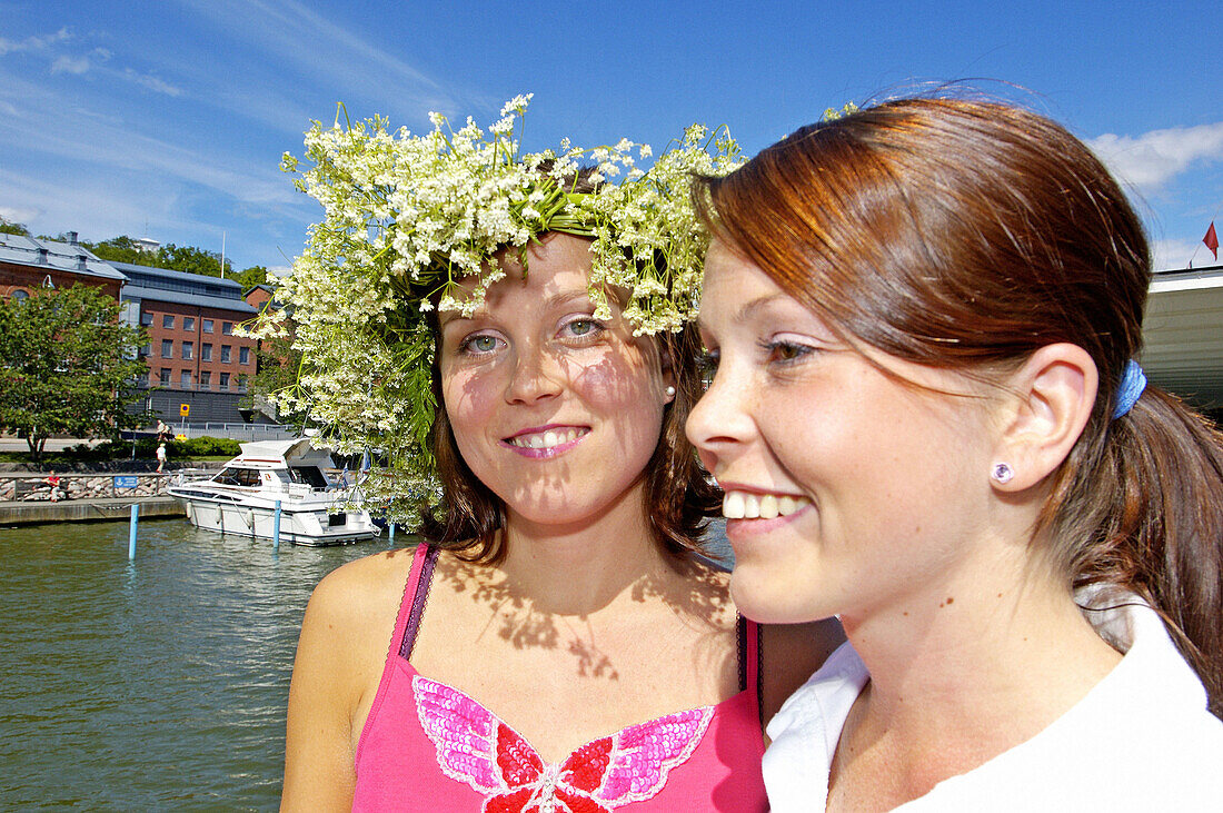 Young woman wearing a flowers crown with her friends on day tour cruise into the Turku archipelago from Turku to Nauvo. Finland