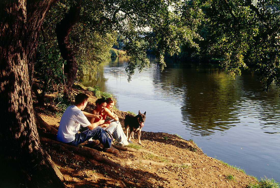 Drei junge Leute machen ein Picknick beim Fluß, Witten, Ruhrtal, Ruhr, Ruhrgebiet, Nordrhein Westfalen, Deutschland