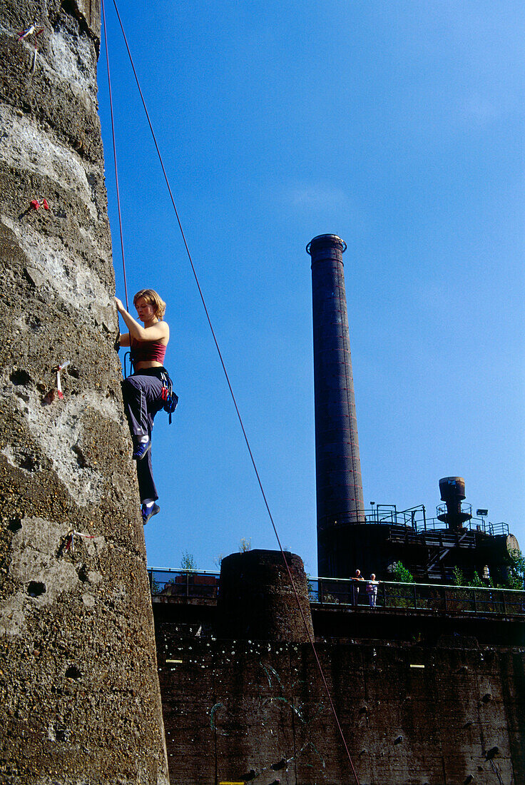 Climber climbing up a tower at Hütte Meiderich, Public Park in Duisburg North, Duisburg, Ruhr Valley, North Rhine Westphalia, Germany