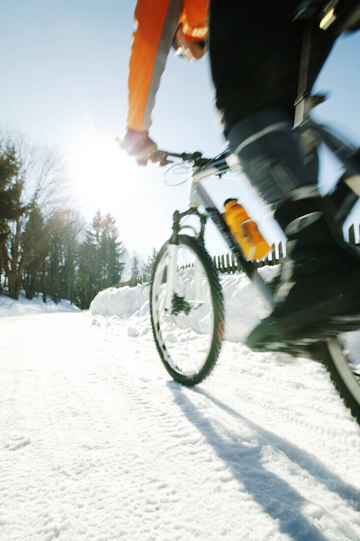 Mann fährt Mountainbike im Schnee, Steiermark, Österreich