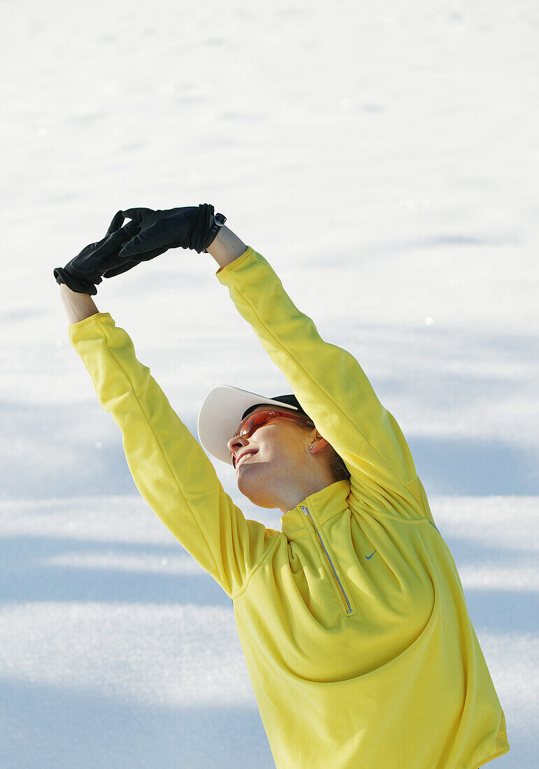 Woman stretching in snow, Styria, Austria