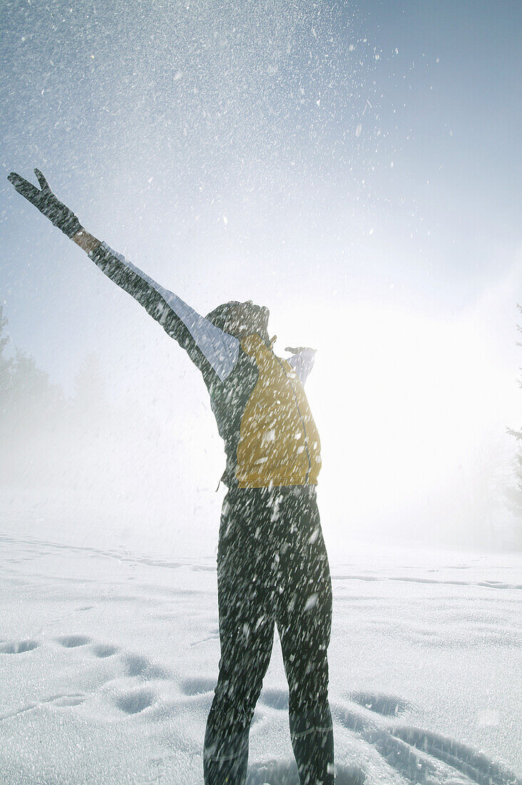 Mann wirft Schnee nach oben, Steiermark, Österreich