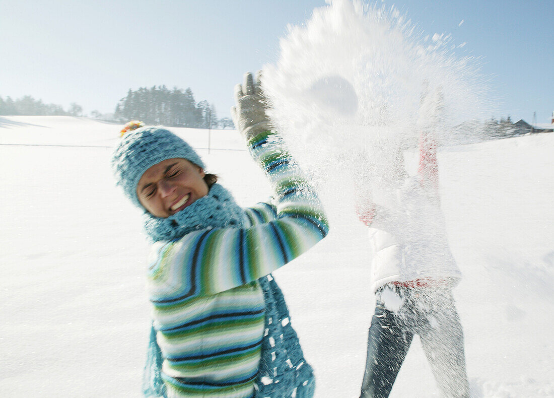 Zwei Frauen machen eine Schneeballschlacht, Steiermark, Österreich