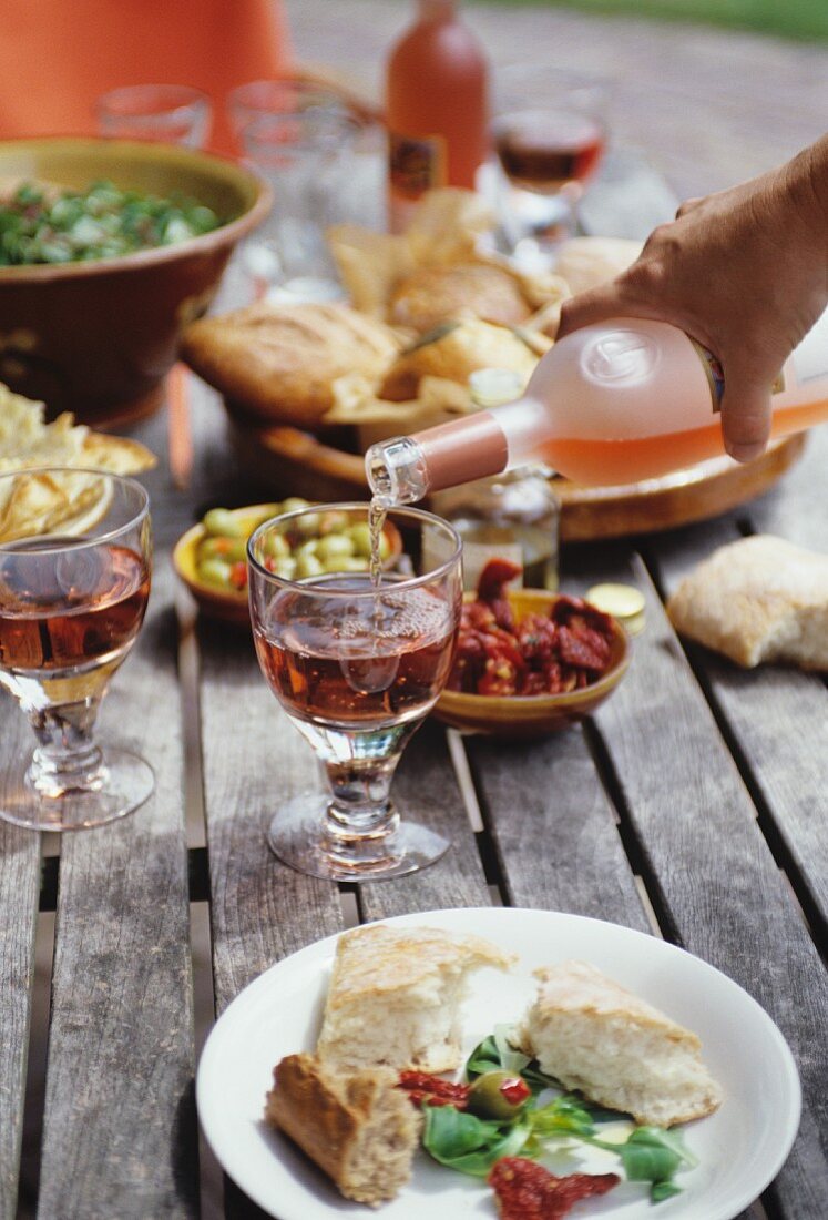 Gedeckter Tisch mit Antipasti und Rosewein im Garten