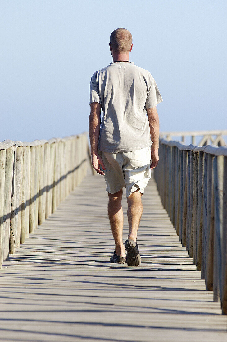  Adult, Adults, Alone, Back view, Beach, Beaches, Color, Colour, Contemporary, Daytime, Determination, Exterior, Footbridge, Footbridges, Full-body, Full-length, Future, Human, Leisure, Male, Man, Men, Men only, One, One person, Outdoor, Outdoors, Outside