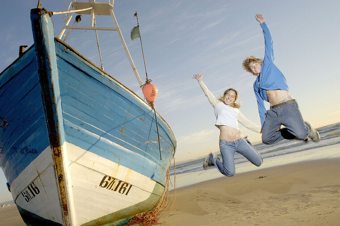 Couple jumping next to stranded fishing boat (Atlantic Ocean)