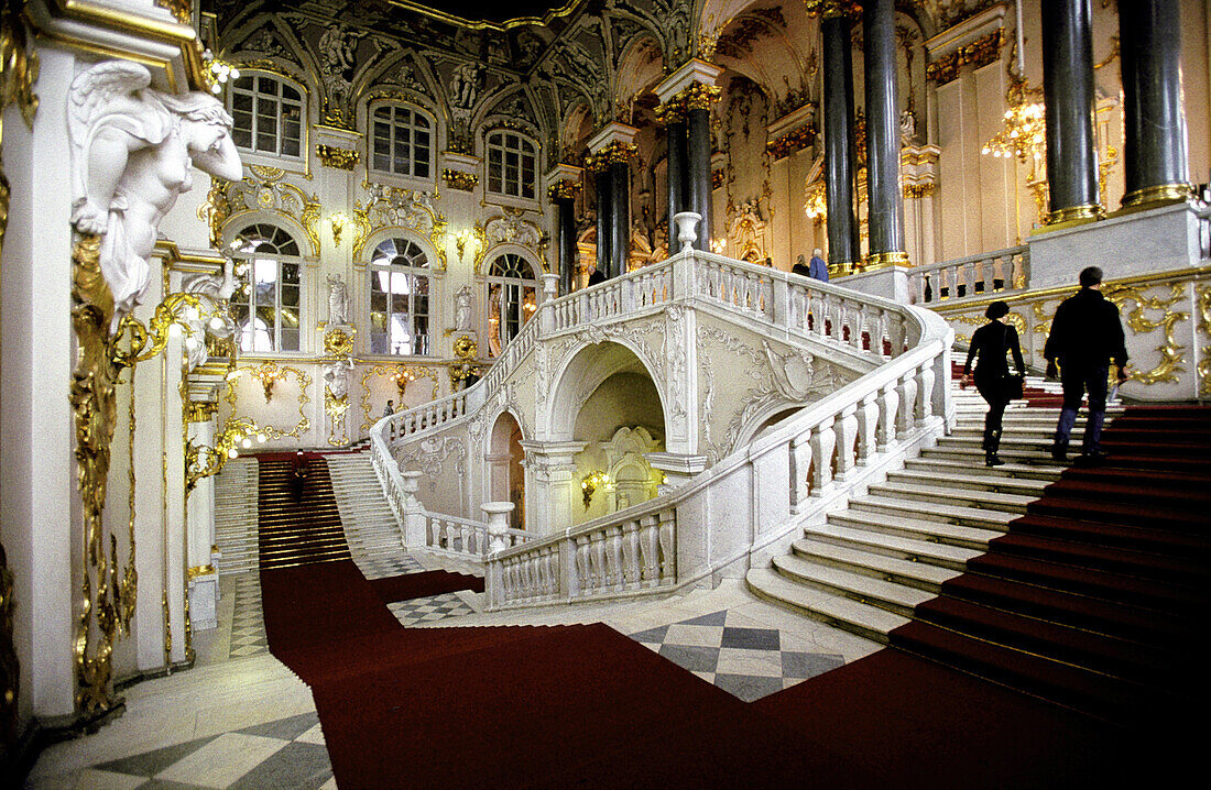 Two visitors climbing the main stairs, interior of the Winter Palace, now Hermitage Museum. St. Petersburg. Russia