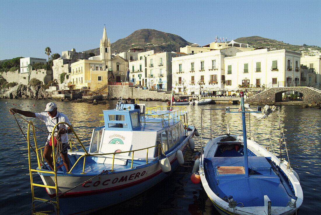 Boatman mooring a boat. Port. Lipari. Aeolian Islands. Sicily. Italy