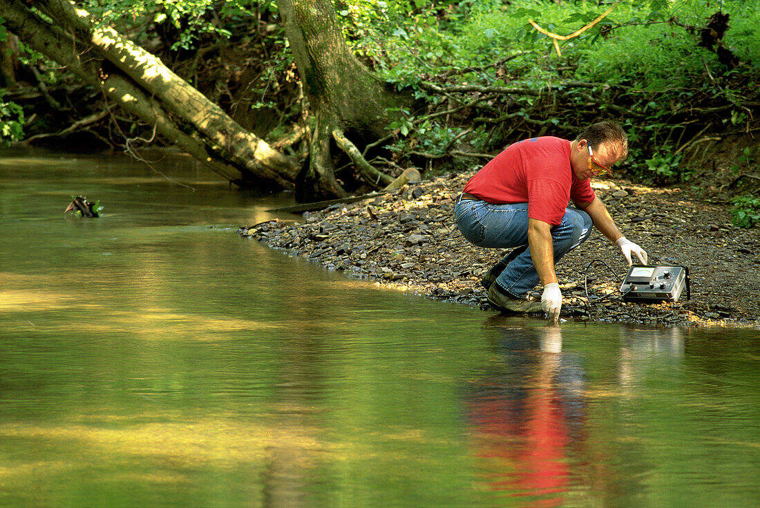 Environmental worker taking water samples at clean-up site