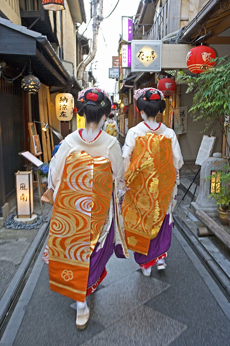 Maikos (geisha apprentices) walking to their evening appointment in the traditional quarters of Gion and Pontocho. Kyoto. Kansai, Japan