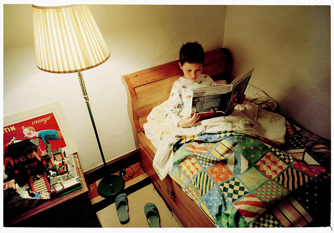Child reading in his room before sleeping.