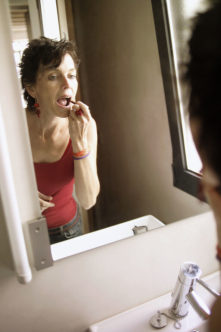 Frau mit Lippenstift vor dem Spiegel