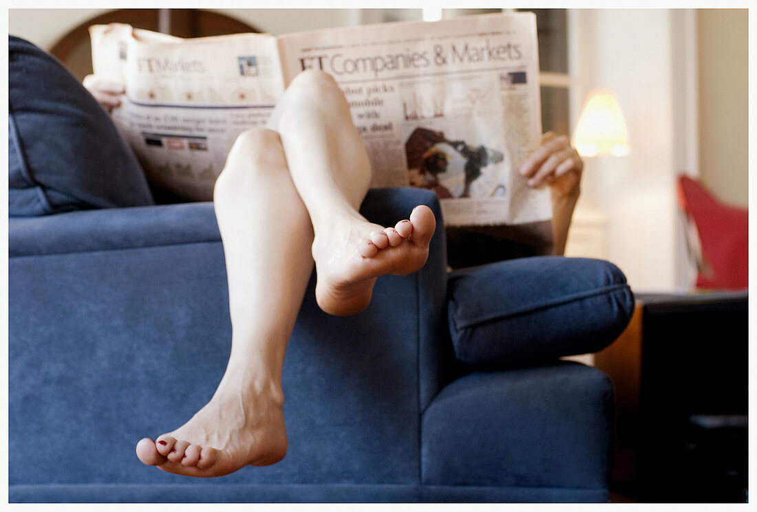  Adult, Adults, At home, Barefeet, Barefoot, Caucasian, Caucasians, Chill out, Chilling out, Color, Colour, Comfort, Comfortable, Contemporary, Couch, Couches, Economy, Feet, Female, Finance, Finances, Financial, Financial newspaper, Financial press, Foot