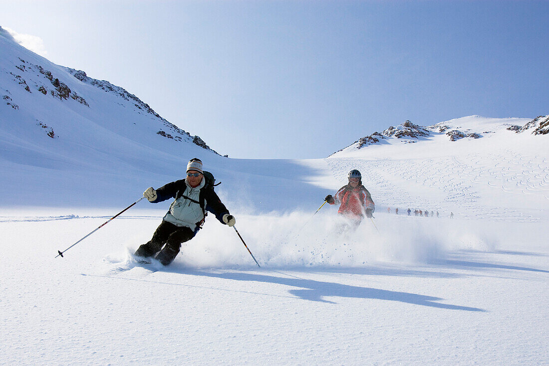 Zwei Skifahrer fahren bergab, Heliskiing in Kamtschatka, Sibirien, Russland