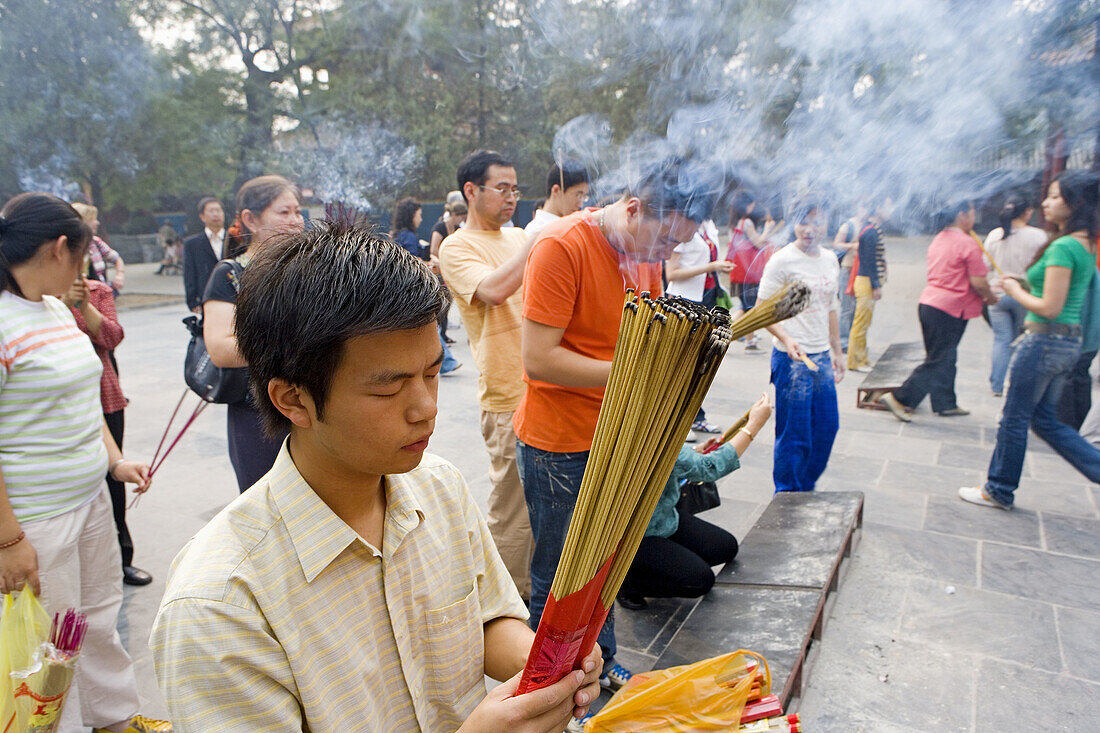 Believers burning incense at Yong he Gong lama temple, Beijing. China