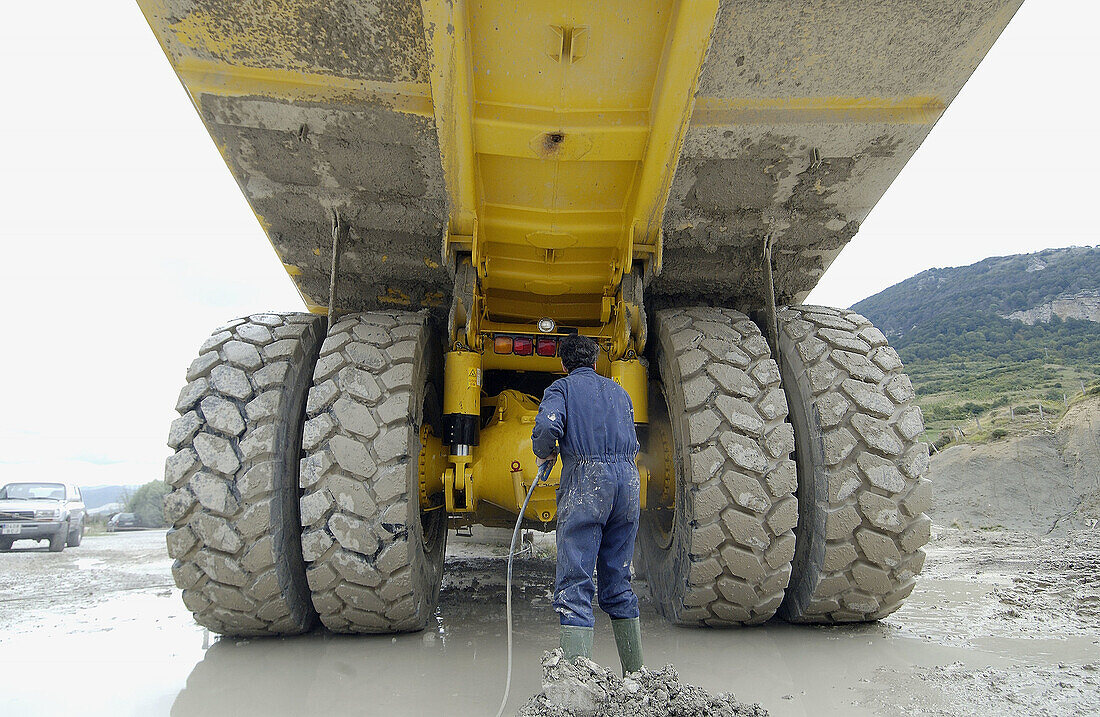 Arbeiter beim Reinigen eines Kippers für den Transport von Mergel vom Steinbruch zum Zementwerk