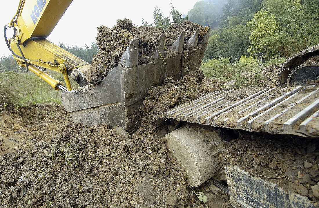 Bau eines Waldweges mit schwarzer Schlacke aus einer Gießerei. Ormaiztegi, Guipúzcoa. Euskadi, Spanien