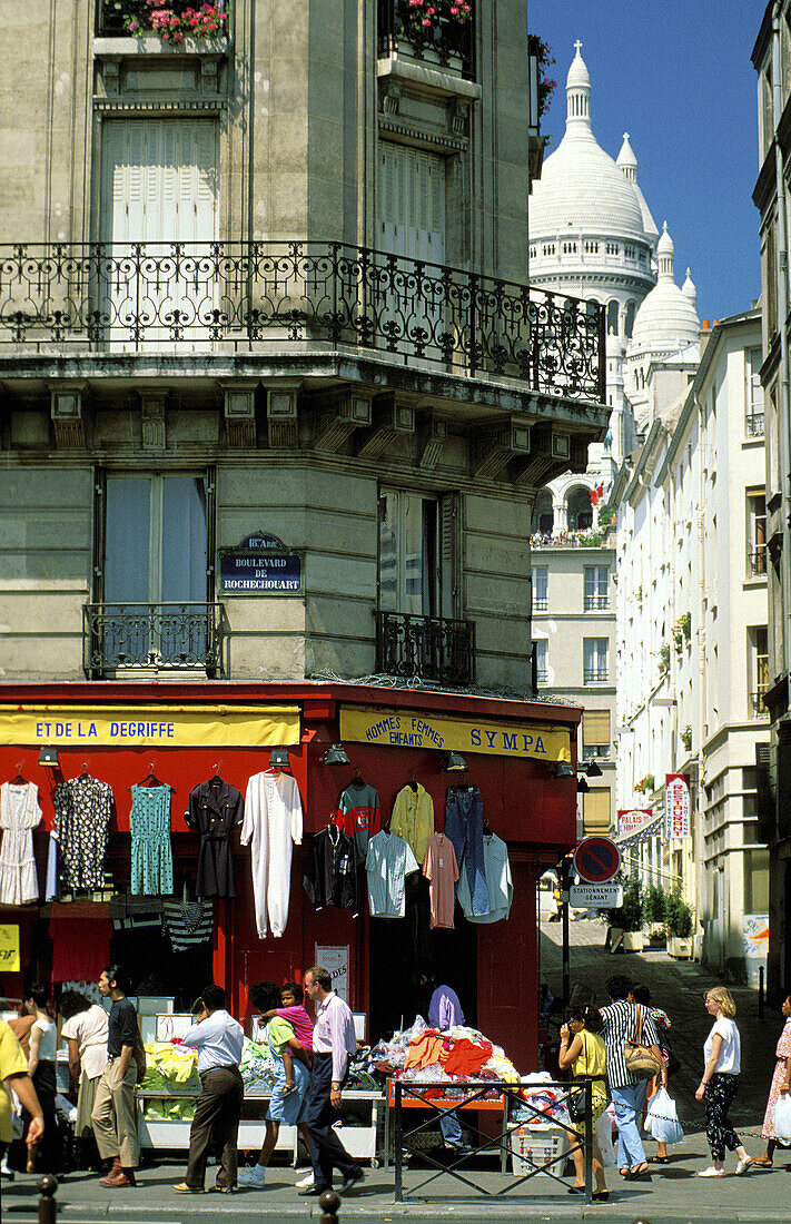 Popular shops at Pigalle area and Sacre Coeur basilica in background. Montmartre, Paris. France