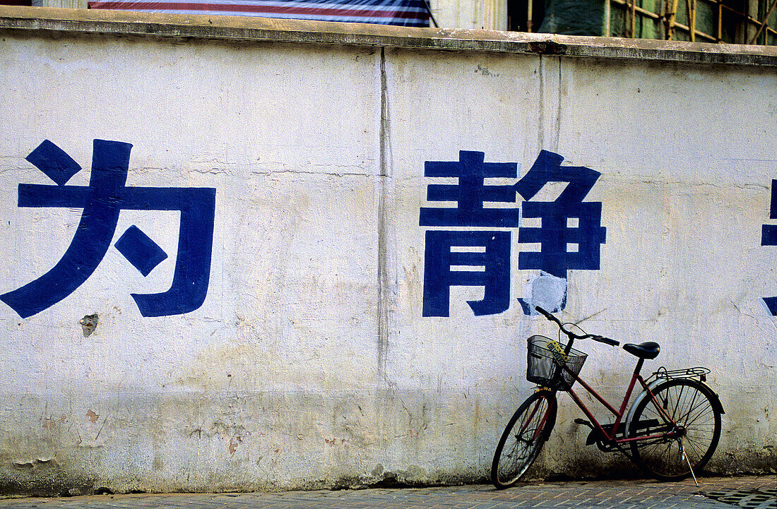 Ideograms painted on wall and bicycles in the old town. Shanghai. China