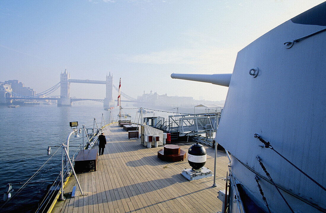 HMS Belfast pointing gun on Tower Bridge. London. England