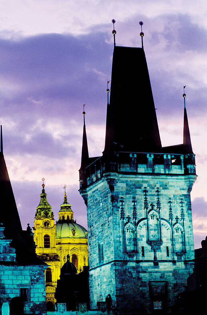 Saint Nicholas baroque church at dusk. Charles Bridge Tower at fore. Mala Strana quarter. Prague. Czech Republic.