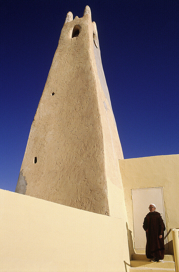 Imam (muslim religious leader) on the top of an ancient mosque. Guardaia Oasis. South Sahara. Argeria