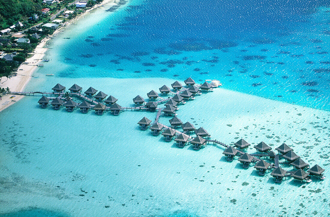 Aerial of luxury hotel huts built on piles on the lagoon. Bora Bora. Leeward Islands. French Polynesia