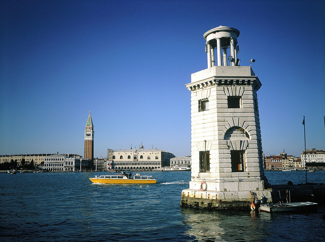Stone lighthouse and St. Mark s area in background viewed from San Giorgio Maggiore. Venice. Italy