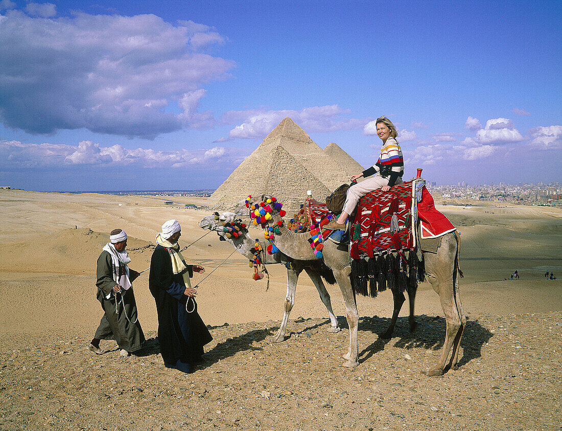 Camel riders with tourist. Pyramids of Gizeh. Egypt