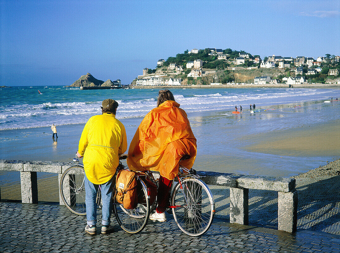 Couple wearing colorful raincoats. Pleneuf-Val-Andre. Cotes d Armor. Brittany. France