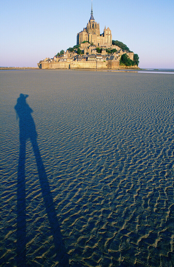 Mont St. Michel at sunrise with a photographer s shadow. Normandy, France