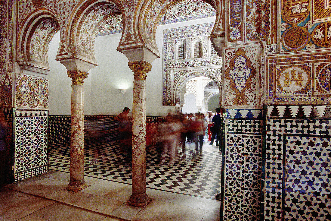 Tourists at the Almohad style rooms and courtyards of the Alcázar palace. Sevilla, Spain