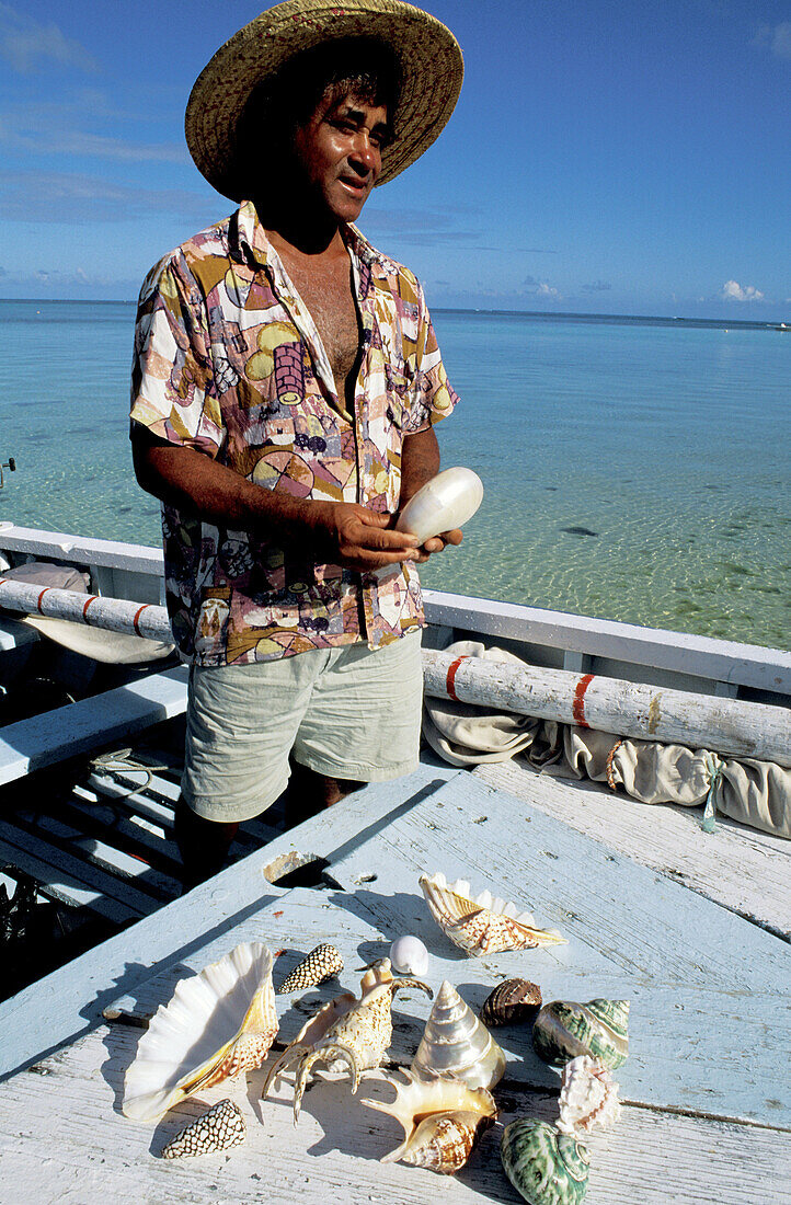Fisherman selling shells on his small boat. Trou-Aux-Biches beach. South West. Mauritius