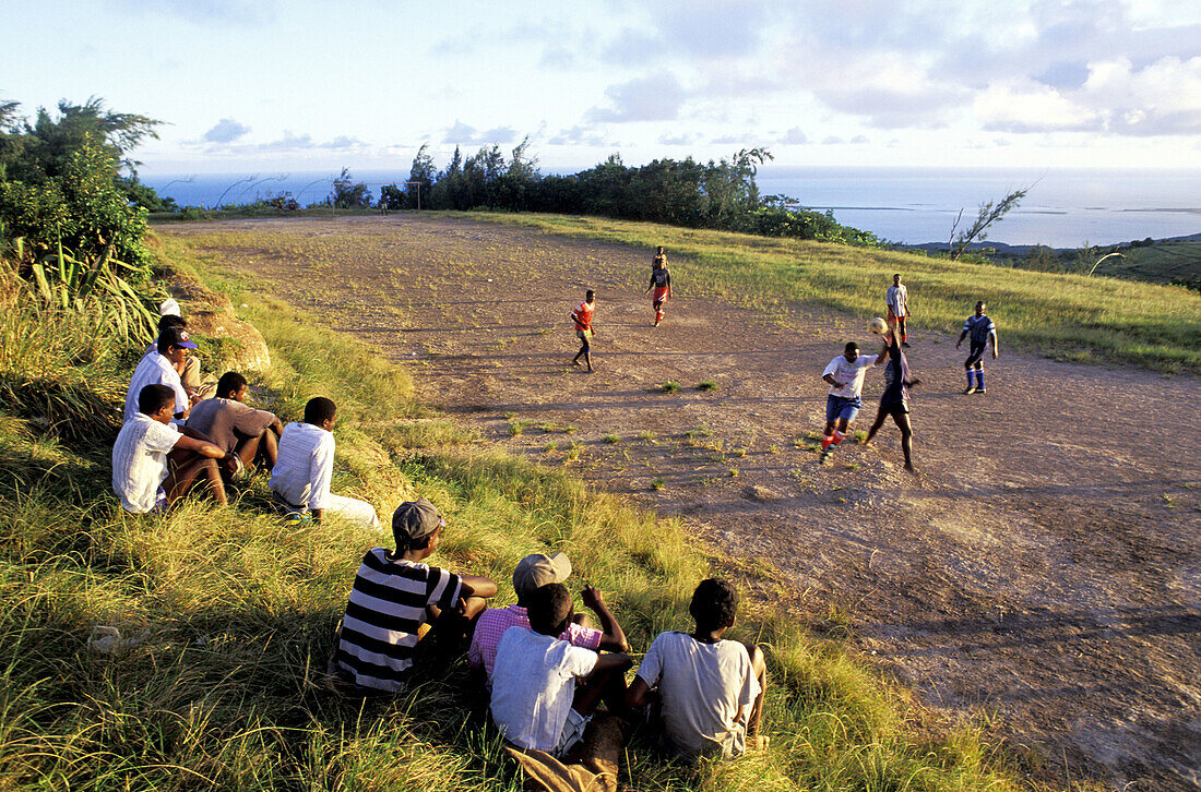 Young boys playing football at dusk. Rodrigues Island. Mauritius