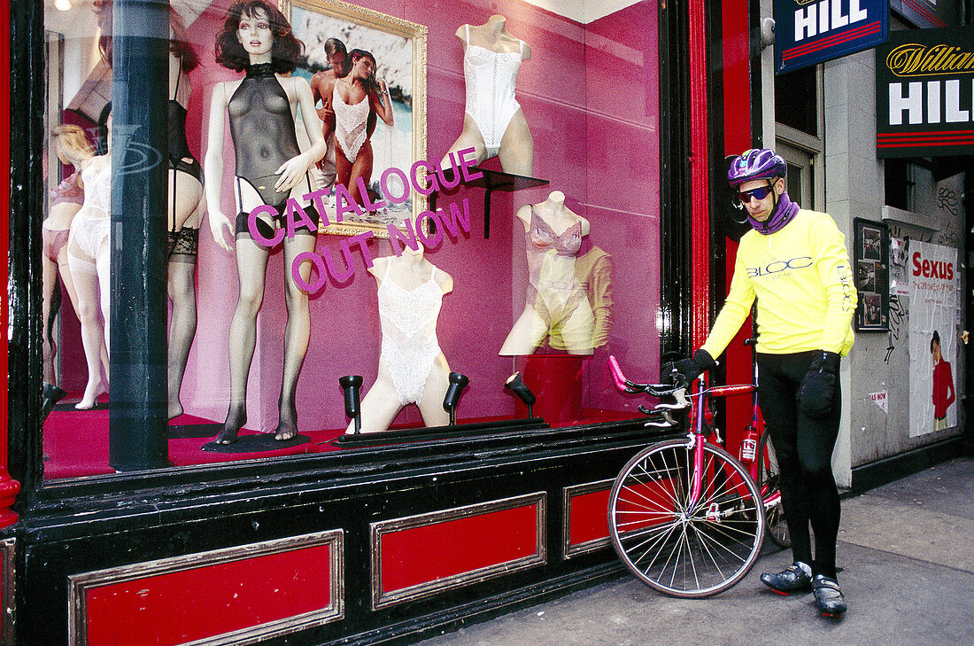 Biker in front of trendy underwear shop. London. England